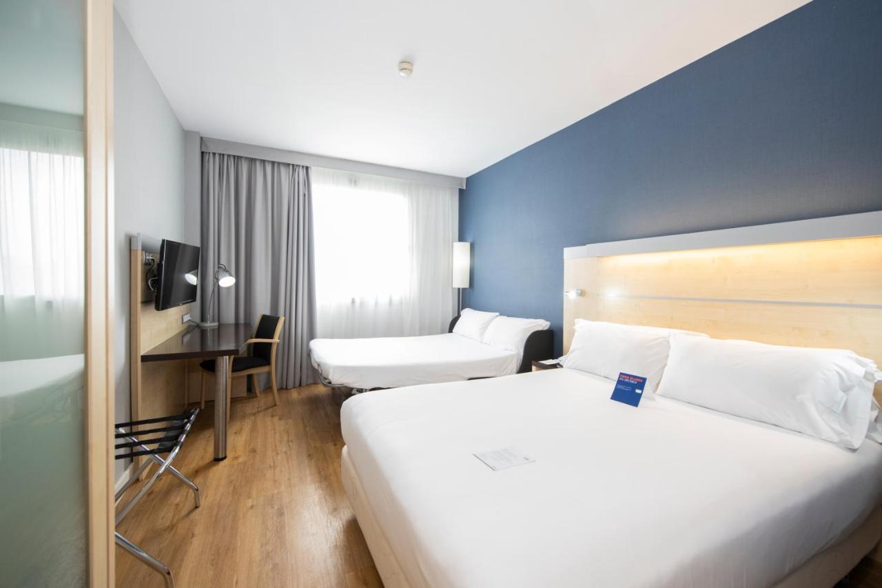 Habitación Doble Estándar con cama doble grande y sofá cama.